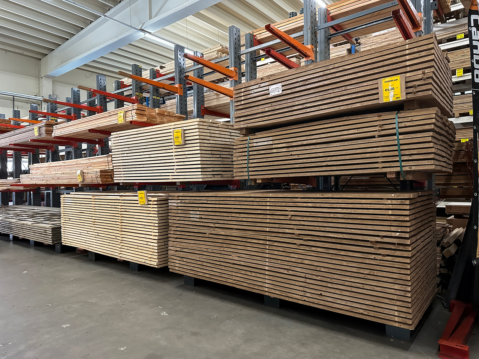 Stapels steigerplanken in de winkel van Bouwie