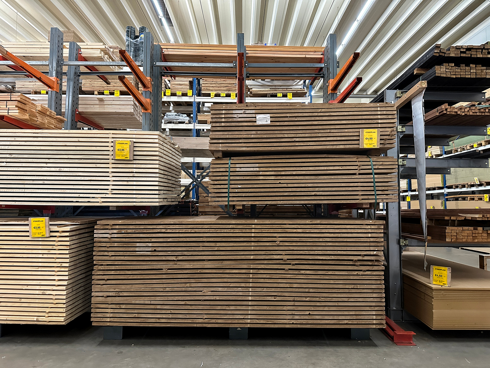 Stapels steigerplanken in de winkel van Bouwie