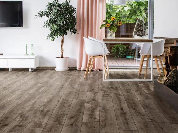 Sfeerbeeld van de fuzion stingray laminaatvloer in een woonkamer met witte stoelen aan een tafel en roze gordijnen voor het raam.